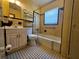 Compact bathroom with yellow tiles, black and white floor tiles and basic fixtures at 2510 Queen S St, St Petersburg, FL 33712