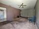 Living room featuring carpeted floor, ceiling fan, and open doorway to the kitchen at 2510 Queen S St, St Petersburg, FL 33712