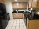 A view of the kitchen featuring wood cabinets, dark countertop and tiled floor at 2701 47Th N Ave, St Petersburg, FL 33714