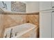 Tiled bathtub with mosaic tile border, with integrated toiletry niche and side storage at 2811 Barret Ave, Plant City, FL 33566