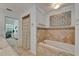 Tiled bathroom featuring a bathtub with decorative tile accents and a view to an adjacent living area at 2811 Barret Ave, Plant City, FL 33566