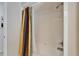 Bathroom shower with tile surround and colorful striped shower curtain, alongside white walls at 2811 Barret Ave, Plant City, FL 33566