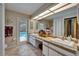 Bathroom featuring double sinks, a vanity area, and an exterior door accessing the pool area at 2811 Barret Ave, Plant City, FL 33566
