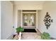 Elegant front door with decorative glass, potted plants, and an ornate wall decoration at 2811 Barret Ave, Plant City, FL 33566