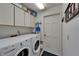 Bright laundry room featuring a washer, dryer, white cabinets, and storage space at 2811 Barret Ave, Plant City, FL 33566