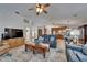 Open-concept living room features a comfortable blue sofa, TV, ceiling fan, and wooden coffee table at 2811 Barret Ave, Plant City, FL 33566