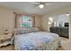 Comfortable main bedroom with ceiling fan, floral bedding, and view into the living area at 2811 Barret Ave, Plant City, FL 33566