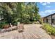 Charming brick paver patio featuring mature trees and a private seating area with flowering bushes at 2811 Barret Ave, Plant City, FL 33566