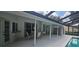 Enclosed patio with a table set, ceiling fan, sliding glass doors, and an adjacent in-ground swimming pool at 2811 Barret Ave, Plant City, FL 33566