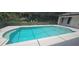 A sunny, screened-in in-ground pool with an adjacent patio surrounded by lush landscaping at 2811 Barret Ave, Plant City, FL 33566