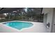 A screened-in in-ground pool with an adjacent patio and a view of the surrounding landscaping at 2811 Barret Ave, Plant City, FL 33566