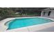 Beautiful screened-in in-ground pool with an adjacent patio surrounded by mature trees and landscaping at 2811 Barret Ave, Plant City, FL 33566