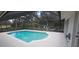 Screened in pool with chairs and lush landscaping in the background, perfect for relaxation and outdoor entertaining at 2811 Barret Ave, Plant City, FL 33566