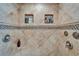 Close-up of a tiled shower with built-in shelves and showerheads with accent tiles at 2811 Barret Ave, Plant City, FL 33566