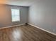 Bedroom featuring wood-look flooring and windows allowing natural light at 3041 Short Leaf St, Wesley Chapel, FL 33543