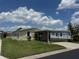 Well-maintained single-story home with covered parking, complemented by neat landscaping and a sunny, partly cloudy sky at 3041 Short Leaf St, Wesley Chapel, FL 33543