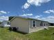 Exterior of a well-kept single-story home with white-trimmed windows and a neat lawn under a sunny, partly cloudy sky at 3041 Short Leaf St, Wesley Chapel, FL 33543
