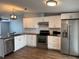 Modern kitchen featuring stainless steel appliances, white cabinets, and hardwood flooring at 3041 Short Leaf St, Wesley Chapel, FL 33543