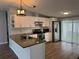 Modern kitchen featuring stainless steel appliances, granite countertops, white cabinets, and hardwood flooring at 3041 Short Leaf St, Wesley Chapel, FL 33543