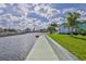 Waterfront property with lush lawn, mature palms, and a concrete seawall at 3181 Gulf Winds Cir, Hernando Beach, FL 34607