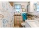 Nautical themed bathroom with custom shower curtain, decorative mirror, and tiled walls at 3181 Gulf Winds Cir, Hernando Beach, FL 34607