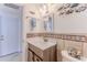Bathroom featuring a shower-tub combo, decorative mirror, tiled walls, and single sink at 3181 Gulf Winds Cir, Hernando Beach, FL 34607
