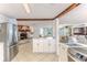 Open-concept living space featuring stainless steel refrigerator and view to living area with fireplace at 3181 Gulf Winds Cir, Hernando Beach, FL 34607