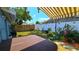 Backyard with a hot tub under a striped awning and a white decorative fence at 3907 Orchard Hill Cir, Palm Harbor, FL 34684