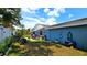 Backyard with a small patio, hot tub, grill, and lush green lawn at 3907 Orchard Hill Cir, Palm Harbor, FL 34684