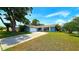 Charming single-story home featuring a large front yard, mature trees, and a concrete driveway at 3907 Orchard Hill Cir, Palm Harbor, FL 34684
