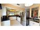 Modern kitchen with stainless steel appliances, white cabinets, and open layout, perfect for cooking at 3907 Orchard Hill Cir, Palm Harbor, FL 34684
