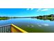 Expansive lake view from a wooden dock with yellow railings, showcasing the tranquil water and distant shoreline at 3907 Orchard Hill Cir, Palm Harbor, FL 34684