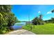 Scenic view of a calm lake surrounded by lush greenery and palm trees, with a wooden dock or pier at 3907 Orchard Hill Cir, Palm Harbor, FL 34684