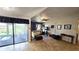 Bright living room featuring tiled floors, decorative ceiling, and sliding doors to a covered lanai at 3907 Orchard Hill Cir, Palm Harbor, FL 34684
