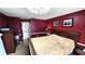 Cozy main bedroom with dark walls, a wooden bed frame, and a view into the Primary bath at 3907 Orchard Hill Cir, Palm Harbor, FL 34684