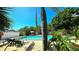 Resort-style community pool with lush tropical landscaping and comfortable lounge chairs for relaxation at 3907 Orchard Hill Cir, Palm Harbor, FL 34684