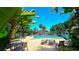Community pool area featuring inviting lounge chairs and a gazebo with lush landscaping at 3907 Orchard Hill Cir, Palm Harbor, FL 34684