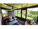 Sunroom featuring cushioned seating and views of the backyard and greenery at 3907 Orchard Hill Cir, Palm Harbor, FL 34684