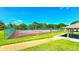 Community tennis court facility with lighting, fenced enclosure, and nearby covered shelter at 3907 Orchard Hill Cir, Palm Harbor, FL 34684
