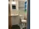 This cozy bathroom features a sink with vanity, toilet, tiled walls, and a storage cabinet above the toilet at 4051 58Th N St # 241C, Kenneth City, FL 33709