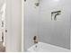 Bright bathroom featuring white subway tile, a gold shower, and a built-in storage nook with greenery at 411 37Th S St, St Petersburg, FL 33711