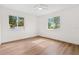Bright bedroom with wood-look flooring and plenty of natural light from the two large windows at 411 37Th S St, St Petersburg, FL 33711