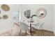 Bright dining area with a white table, four plush chairs, stylish light fixture, and decorative wall art at 411 37Th S St, St Petersburg, FL 33711