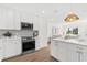 Modern kitchen with stainless steel appliances, granite countertops, and an adjacent living area at 411 37Th S St, St Petersburg, FL 33711
