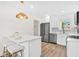 Modern kitchen with stainless steel appliances, quartz countertops, and a breakfast bar area at 411 37Th S St, St Petersburg, FL 33711