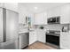 Bright modern kitchen with stainless steel appliances, granite countertops, and white cabinets at 411 37Th S St, St Petersburg, FL 33711