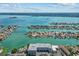 Stunning aerial view of a residential area with canals, docks, and multiple waterfront properties under a sunny sky at 415 Island Way # 303, Clearwater Beach, FL 33767