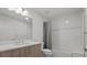 Bright bathroom featuring modern vanity with double sinks and glass enclosed shower and tub at 415 Island Way # 303, Clearwater Beach, FL 33767