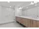 Modern bathroom featuring double sinks, a glass shower, and contemporary lighting at 415 Island Way # 303, Clearwater Beach, FL 33767