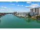 Beautiful waterfront property featuring boat docks, lush landscaping and modern architecture on a sunny day at 415 Island Way # 303, Clearwater Beach, FL 33767